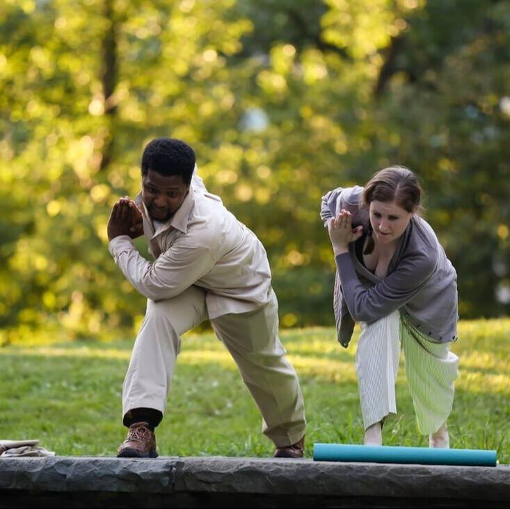 Production photo from Bethel Park Falls of two cast members .stretching outdoors